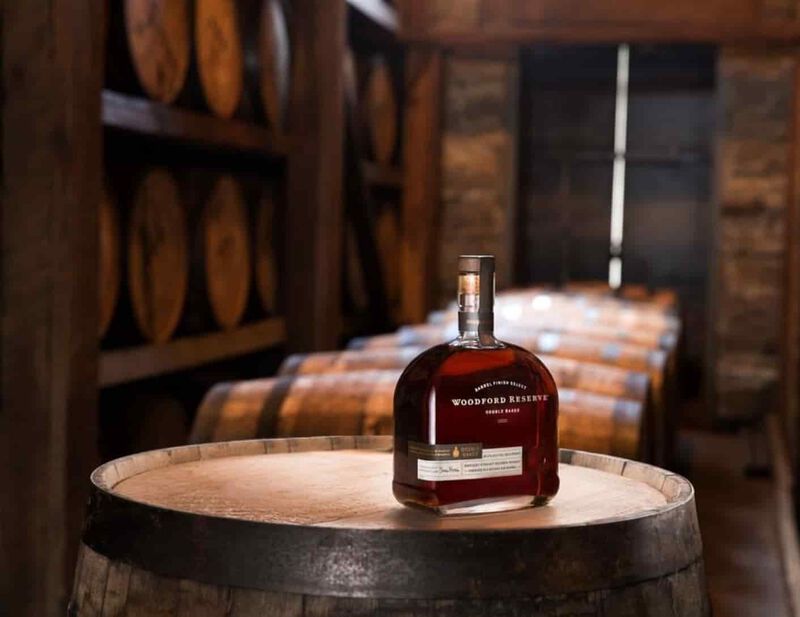 A bottle of Woodford Reserve sits on top of a barrel